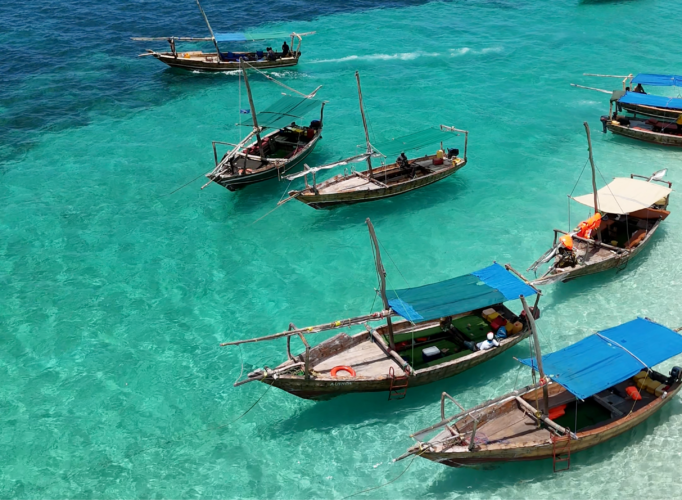 Traditional wooden dhows anchored in clear turquoise water in Zanzibar