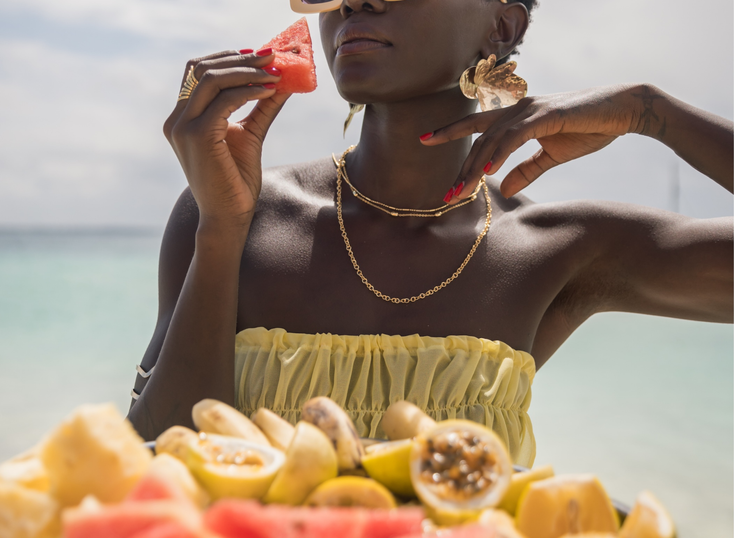 Woman eating fresh watermelon with a plate of tropical fruit